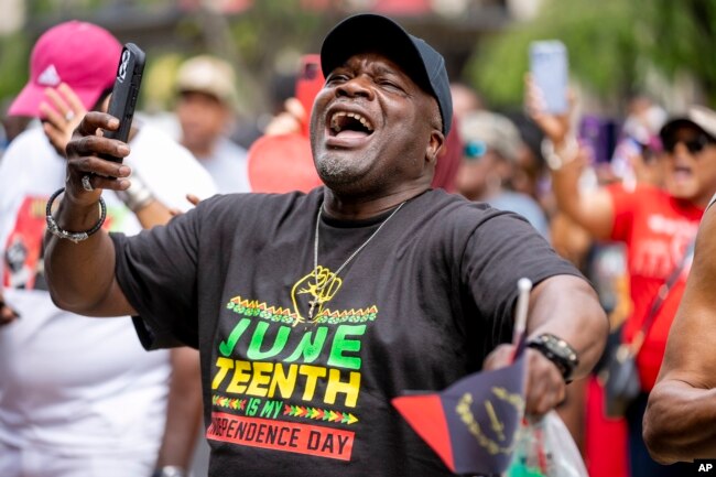 FILE - Tyrone Stroman, of Washington, wears a T-shirt that reads "Juneteenth is my Independence Day" as he dances to an Earth, Wind, and Fire Tribute Band during a Juneteenth celebration at Black Lives Matter Plaza in Washington, Monday, June 19, 2023. (AP Photo/Andrew Harnik)