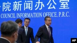 Chinese Foreign Minister Wang Yi, right, leaves after a press conference at the State Council Information Office in Beijing, Sept. 26, 2023. 