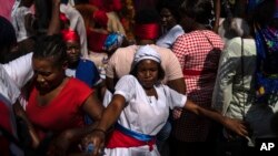 FILE - A Vodouist clad in white invokes a gede spirit during the Saint George celebration, in Port-au-Prince, Haiti, April 24, 2024. 