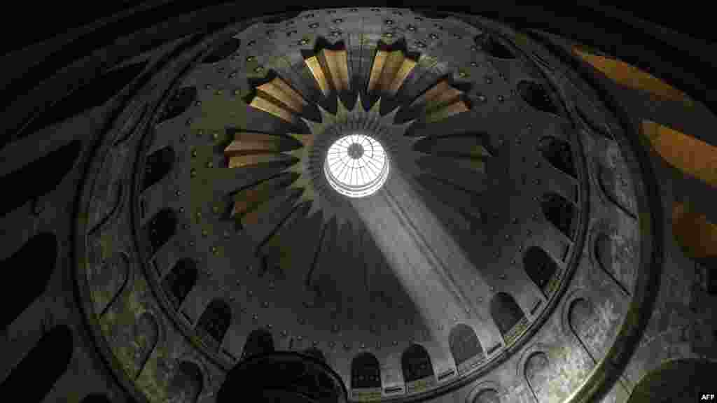 Light shines over the Edicule, traditionally believed to be the burial site of Jesus Christ, at the Church of the Holy Sepulchre in the Old City of Jerusalem, during the Orthodox Good Friday. (Photo by RONALDO SCHEMIDT / AFP)