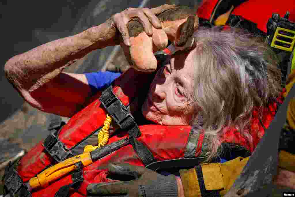 Firefighters and emergency medical personnel move a resident of a care home, who was trapped in their home overnight, to an ambulance following Tropical Storm Hilary in Cathedral City, California, Aug. 21, 2023.
