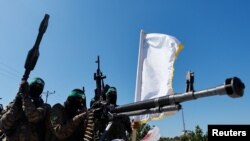  Боевики ХАМАС принимают участие в военном параде, посвященном годовщине войны с Израилем в 2014 году, недалеко от границы в центральной части сектора Газа, 19 июля 2023 года.