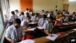 FILE - Students wearing face masks as a precaution against the coronavirus attend classes in Ahmedabad, India, Sept. 1, 2021. 