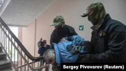 (FILE) Russia's Federal Security Service escort a purported member of the the Ukrainian armed forces.