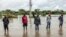 FILE - Residents inspect a road heavily affected by floods following torrential rains in Kitengela, on May 1, 2024. 