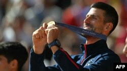 Gold medallist, Serbia's Novak Djokovic poses with his medal on the podium at the presentation ceremony for the men's singles tennis event on Court Philippe-Chatrier at the Roland-Garros Stadium during the Paris 2024 Olympic Games, Aug. 4, 2024.