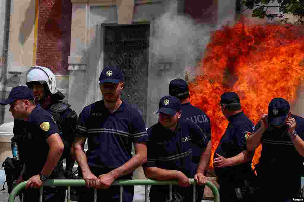 Police officers react as supporters of the opposition hurl Molotov cocktails at the mayor&#39;s office accusing him of corruption in Tirana, Albania.&nbsp;