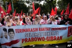 Para pendukung Menteri Pertahanan Indonesia dan Presiden terpilih Prabowo Subianto bersorak di dekat gedung KPU di Jakarta, Rabu, 24 April 2024. (AP/Achmad Ibrahim)
