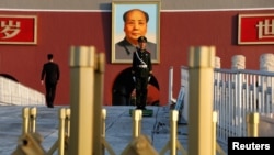 Polisi paramiliter berdiri di depan foto mantan pemimpin China Mao Zedong di gerbang Tiananmen, China, 8 November 2017. (Foto: Reuters)