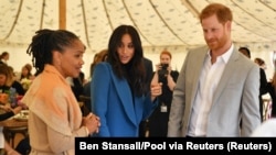 Prince Harry akiwa na mkewe Meghan, na mama wa Meghan, Doria Ragland. 20 Sept. 2018 (arquivo)