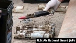 FILE - In this image provided by the U.S. Air National Guard, U.S. Air Force National Guard Explosive Ordnance Disposal Techinicians prepare several contaminated and compromised depleted uranium rounds, June 23, 2022, at Tooele Army Depot, Utah.