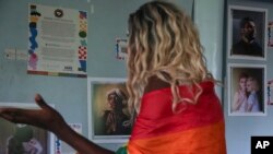 Ugandan transgender woman Pretty Peter looks at portraits from a global project called "Where Love is Illegal," at the safe house where she lives in Nairobi, Kenya, June 1, 2023. 