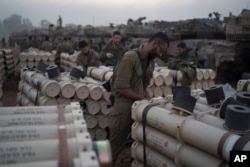 Israeli soldiers from the artillery unit store tank shells in a staging area at the Israeli-Gaza border in southern Israel, Jan. 1, 2024.
