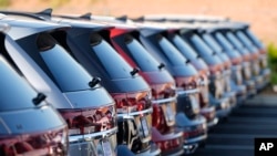 FILE - A long row of unsold 2024 Atlas utility vehicles is shown, July 28, 2024, at a Volkswagen dealership in Denver. 