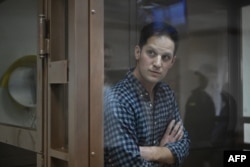 US journalist Evan Gershkovich, arrested on espionage charges, stands inside a defendants' cage before a hearing to consider an appeal on his arrest at the Moscow City Court in Moscow, Apr. 18, 2023