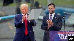 Republican presidential nominee former President Donald Trump, left, and Republican vice presidential nominee Sen. JD Vance appear on stage during a campaign event in Asheboro, North Carolina, Aug. 21, 2024. 