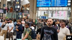 Travelers wait inside the Gare du Nord train station at the 2024 Summer Olympics, July 26, 2024, in Paris.