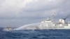 In this handout photo provided by the Philippine Coast Guard, a Chinese coast guard ship uses water cannons on Philippine navy-operated supply boat M/L Kalayaan as it approaches Second Thomas Shoal in the disputed South China Sea on Dec. 10, 2023.