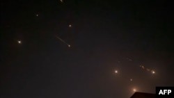 This video grab from AFPTV taken on April 14, 2024 shows explosions lighting up the sky in Hebron in the Israeli-occupied West Bank during an Iranian attack on Israel. 