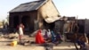 FILE - People sit near a burned house after an attack by suspected members of the Islamist Boko Haram militant group, in Bulabulin village, Nigeria, Nov. 1, 2018. 