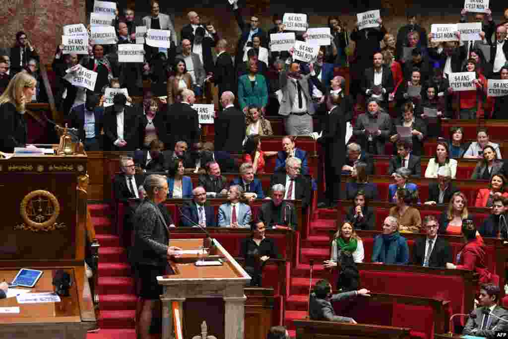 Members of left-wing coalition NUPES (New People&#39;s Ecologic and Social Union) hold placards during the speech of France&#39;s Prime Minister Elisabeth Borne (C), as she confirms to force through a proposed pension bill without a parliament vote during a session regarding the government&#39;s pension reform at the lower house National Assembly, in Paris.