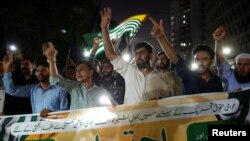 People hold a banner in support of an alliance of civil rights groups protesting in Pakistan-ruled Kashmir, demanding the government give the region a subsidy on electricity and wheat prices, during a demonstration in Karachi, May 13, 2024. 