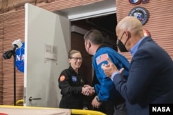 NASA’s CHAPEA crew member Kelly Haston greets Deputy Director of Flight Operations Kjell Lindgren and Johnson Space Center Deputy Director Stephen Koerner at the habitat’s door. (NASA/Josh Valcarcel)