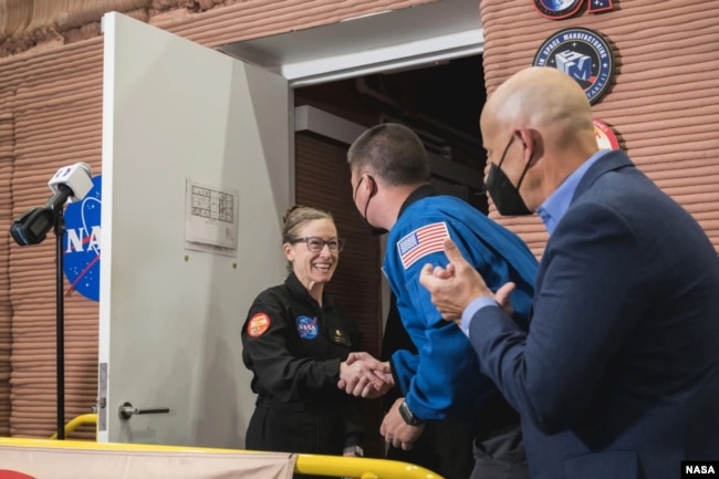 NASA’s CHAPEA crew member Kelly Haston greets Deputy Director of Flight Operations Kjell Lindgren and Johnson Space Center Deputy Director Stephen Koerner at the habitat’s door. (NASA/Josh Valcarcel)