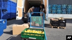 Volunteer for Le Maillon Manuel Pintos loads goods into a vehicle for food distribution, Aug. 6, 2024, during the 2024 Summer Olympics, in Gennevilliers, France. 