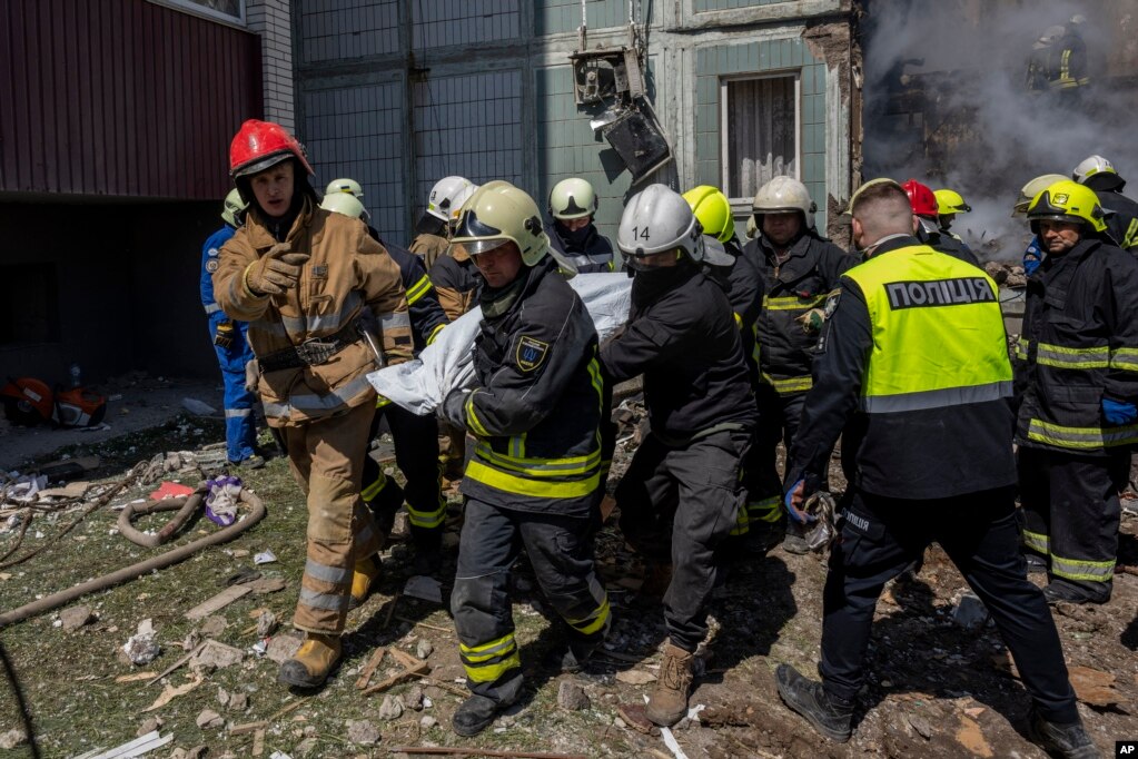 俄军袭击乌克兰乌曼市的居民楼后，乌克兰消防队员从楼房废墟中抬出死难者。（2023年4月28日）(photo:VOA)