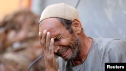 Hassan El Salheen weeps after burying the repatriated body of his son, Aly, who died along with his three cousins in Libya after Storm Daniel hit the country, at Al Sharief village in Bani Swief province, Egypt.