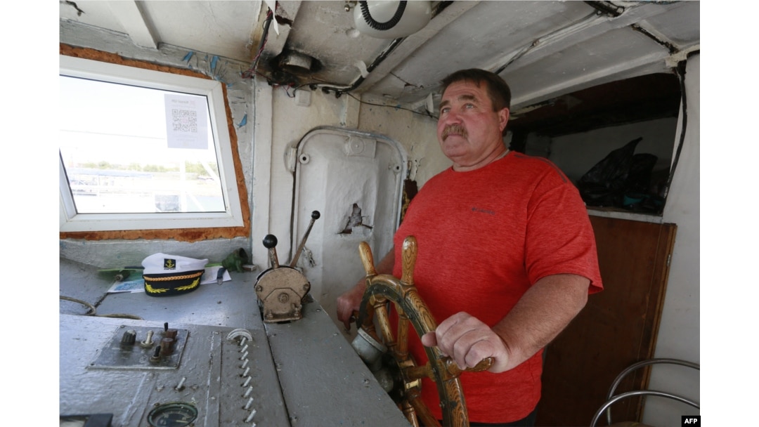Fisherman Alexei Grebennikov steers his boat on Lake Balkhash in Kazakhstan on June 18, 2024. "There are fewer and fewer fish," he says. "It's catastrophic; the lake is silting up."