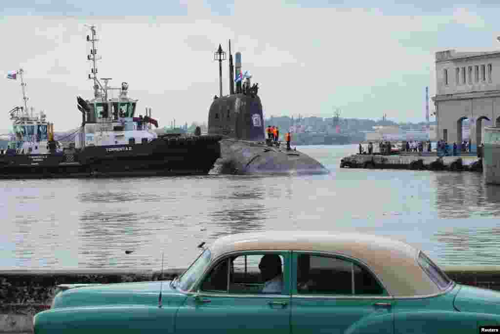 Un coche antiguo pasa mientras el submarino ruso de misiles de crucero de propulsión nuclear Kazán atraca en la bahía de La Habana, Cuba, el 12 de junio de 2024.&nbsp;