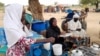 Fatma Dahab Ousman, a Sudanese refugee who fled the violence in her country, sells tea and porridge to other refugees near the border between Sudan and Chad, in Koufroun, Chad, May 1, 2023. 