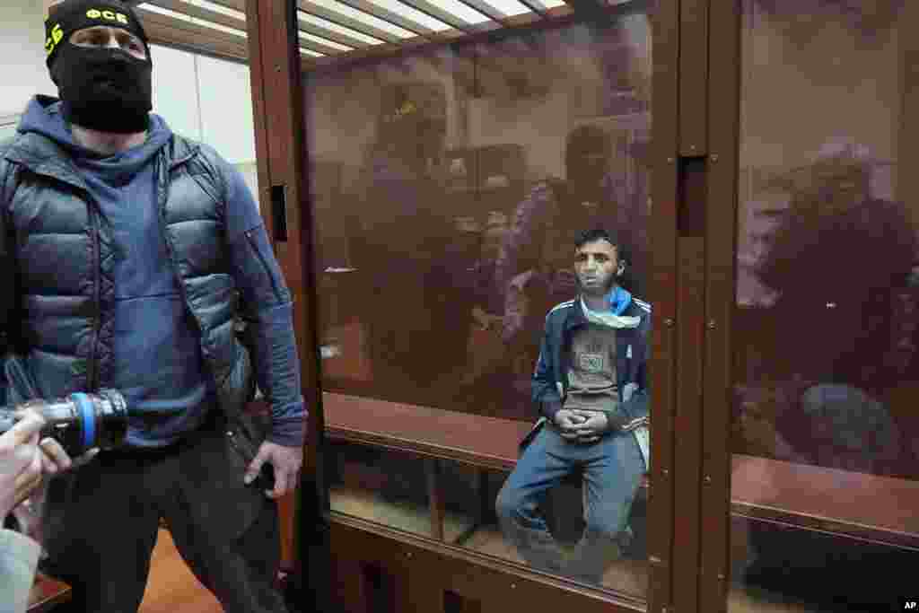 Dalerdzhon Mirzoyev, a suspect in the Crocus City Hall shooting on Friday, sits in a glass cage in the Basmanny District Court in Moscow, Russia, March 24, 2024. 