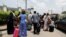 Passengers walk with their luggage past soldiers as protesters block the domestic terminal of Murtala Muhammed International airport during a strike over working conditions and wages, in Lagos, Nigeria, April 17, 2023.