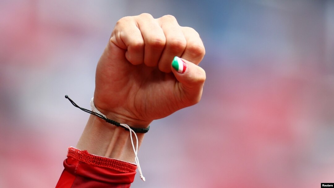 FILE - An Iranian woman runner with her thumbnail painted in the colors of the Iranian national flag clenches her fist after a race.