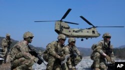 Tentara Angkatan Darat AS menunggu untuk menaiki helikopter CH-47 Chinook mereka selama latihan militer bersama Korea Selatan dan Amerika Serikat di Rodriguez Live Fire Complex di Pocheon, Korea Selatan, Minggu, 19 Maret 2023. (AP/Ahn Young-joon)