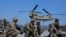 Tentara Angkatan Darat AS menunggu untuk menaiki helikopter CH-47 Chinook mereka selama latihan militer bersama Korea Selatan dan Amerika Serikat di Rodriguez Live Fire Complex di Pocheon, Korea Selatan, Minggu, 19 Maret 2023. (AP/Ahn Young-joon)