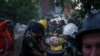 Rescue workers and police officers carry an injured person by a stretcher to an ambulance from a building which was destroyed by a Russian airstrike in Kharkiv, Ukraine, June 10, 2024. 