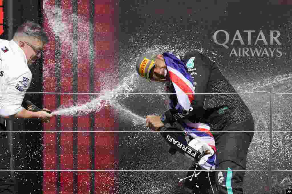 Mercedes driver Lewis Hamilton of Britain, right, celebrates on the podium with Peter Bonnington, Mercedes race engineer, after winning the British Formula One Grand Prix race at the Silverstone racetrack, Silverstone, England.