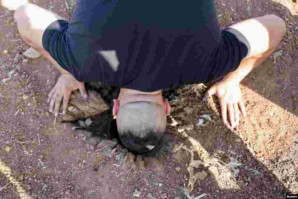 A man investigates the scene where three Palestinian gunmen were killed by an Israeli drone strike, near Jenin, in the Israeli-occupied West Bank.