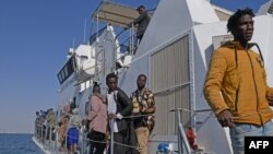 Des migrants d'Afrique subsaharienne sont secourus par la Garde nationale tunisienne de leurs bateaux de fortune qui ont été utilisés pour se rendre sur la côte italienne, à environ 50 milles marins en mer Méditerranée au large de la ville de Sfax, au centre de la Tunisie.