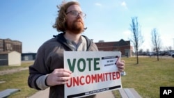 Eric Suter-Bull holds a Vote Uncommitted sign outside a voting location at Saline Intermediate School for the Michigan primary election in Dearborn, Feb. 27, 2024.