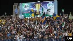 Supporters cheer during the final match of a football tournament at the municipal stadium in Syria's rebel-held city of Idlib, where football has become an escape valve amid years of conflict and misery, Aug. 18, 2023.