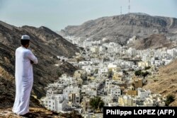 Seorang pria berdiri di atas bukit di al-Wadi al-Kabir sebelah barat ibu kota Oman, Muscat, pada 14 Februari 2018. (Foto: Philippe LOPEZ/AFP)