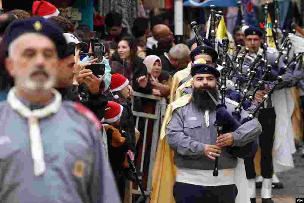  Una banda de scouts palestinos dessfila ante el público el 24 de diciembre del 2022, durante el tradicional desfile navideño, que este año ha sido suspendido en solidaridad con las víctimas de la guerra en Gaza. &nbsp; 