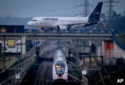 Sebuah pesawat Lufthansa melintas di atas jalur kereta api di Frankfurt, Jerman, Rabu, 6 Maret 2024. (AP /Michael Probst)