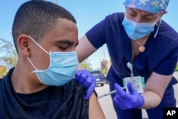 Nurses with the Mount Sinai South Nassau Vaxmobile administer the COVID-19 vaccine at a school in Freeport, New York, May 14, 2021.