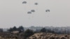 Humanitarian aid falls through the sky toward the Gaza Strip after being dropped from an aircraft, amid the ongoing conflict between Israel and the Palestinian Islamist group Hamas, as seen from Israel, March 28, 2024. 